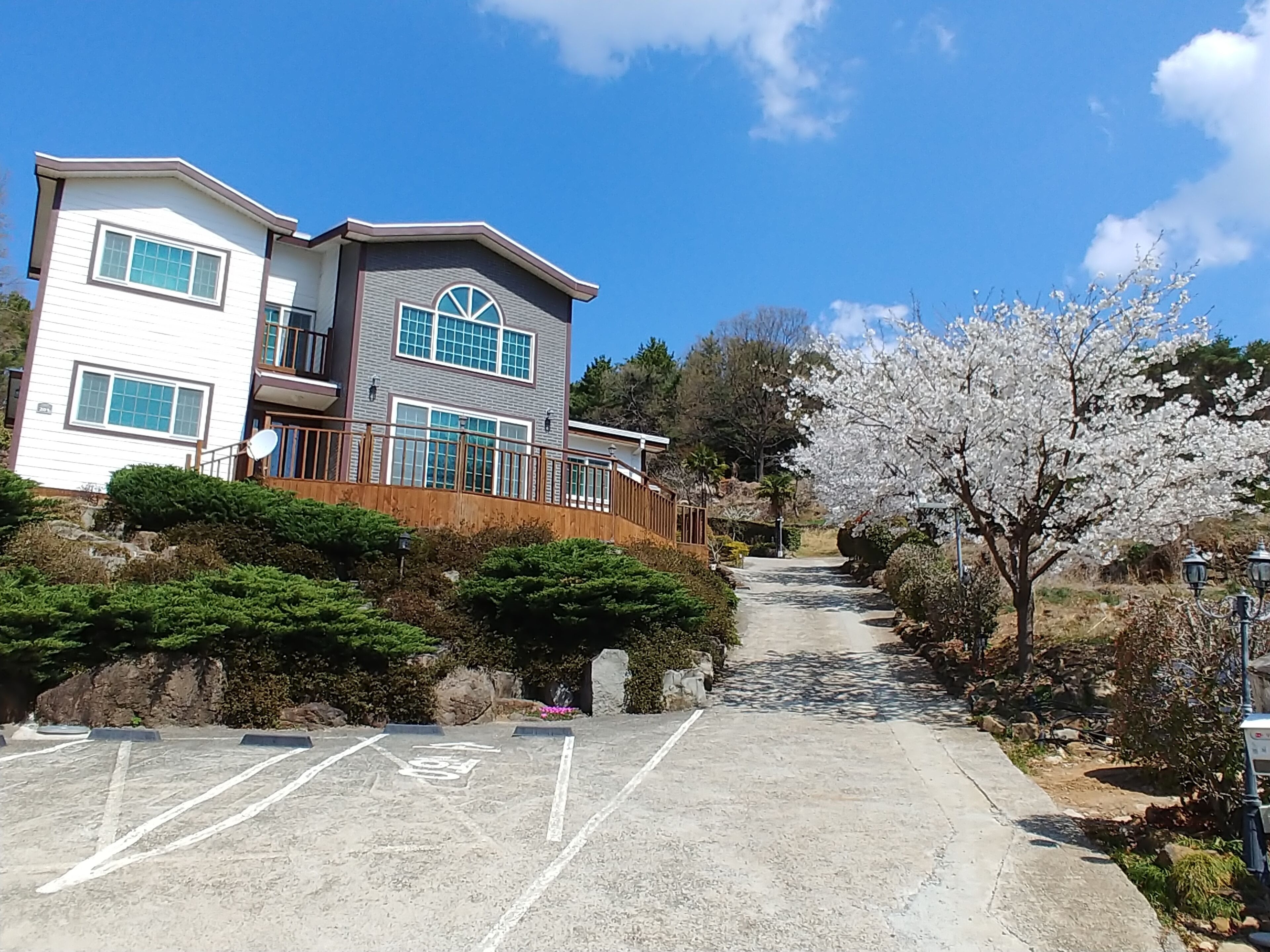 A residential building with a driveway leading to a parking area.