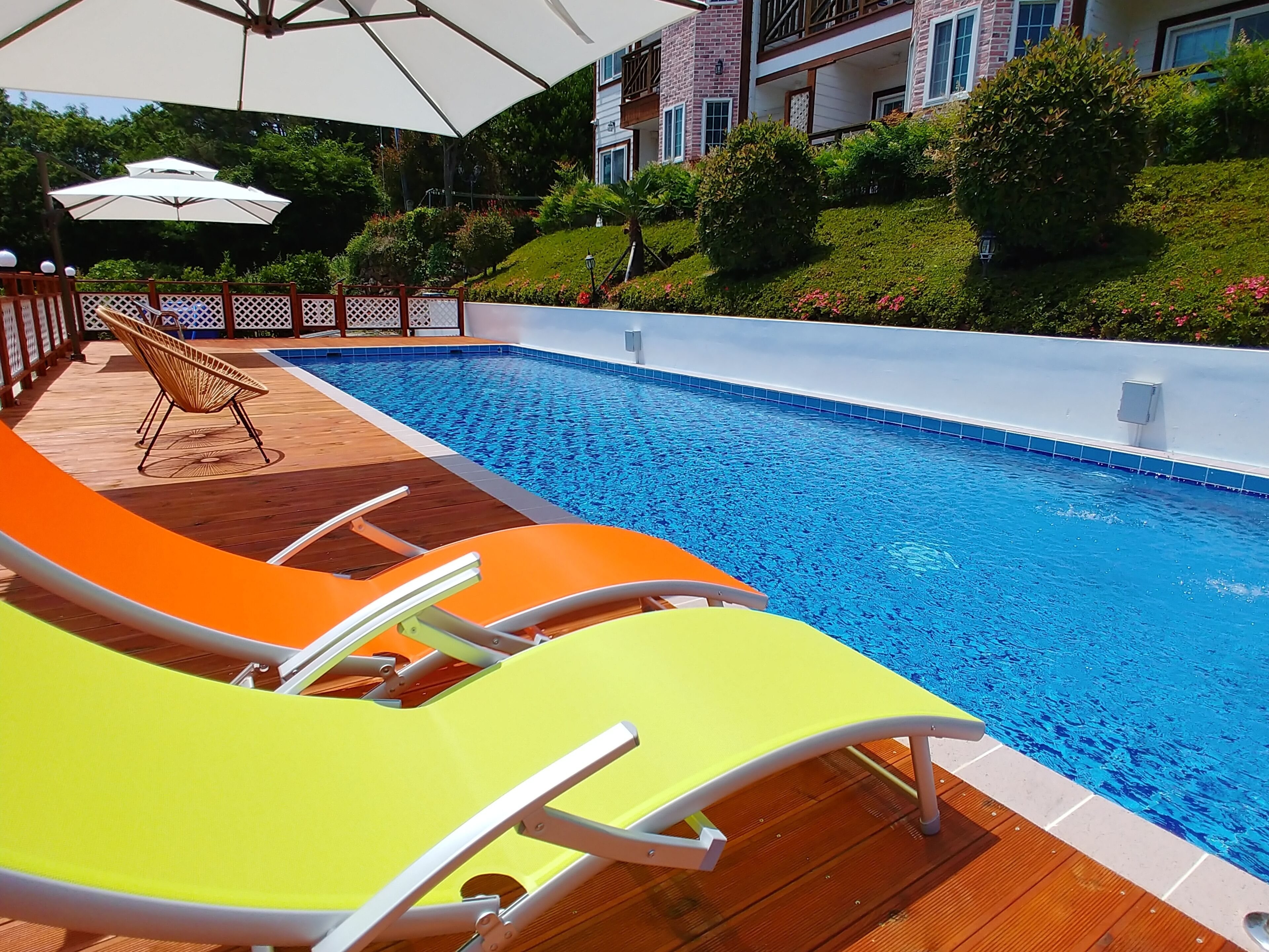 Una piscina al aire libre de temporada, sombrillas