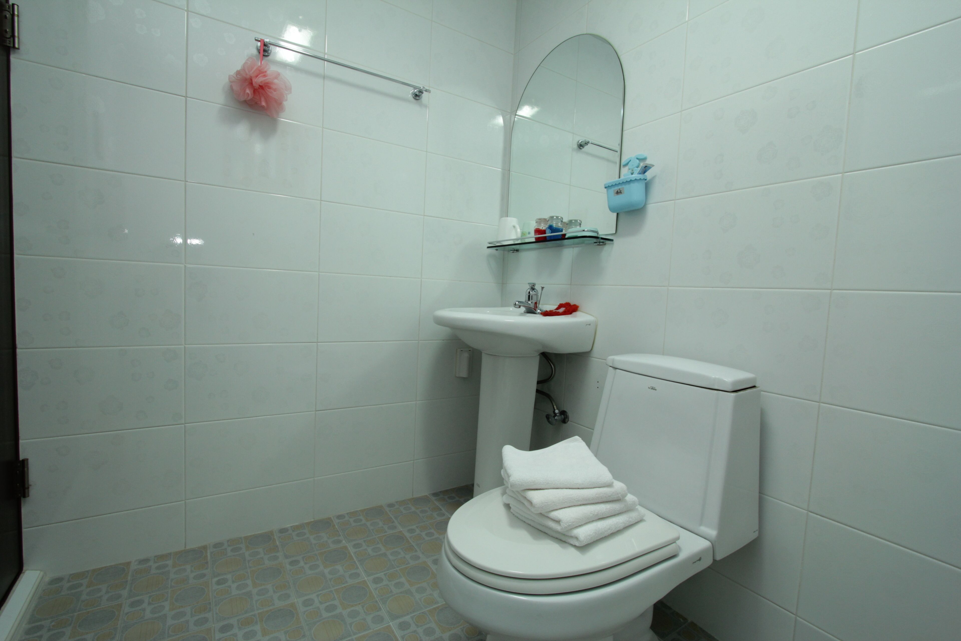 A bathroom with a toilet, sink, and mirror.
