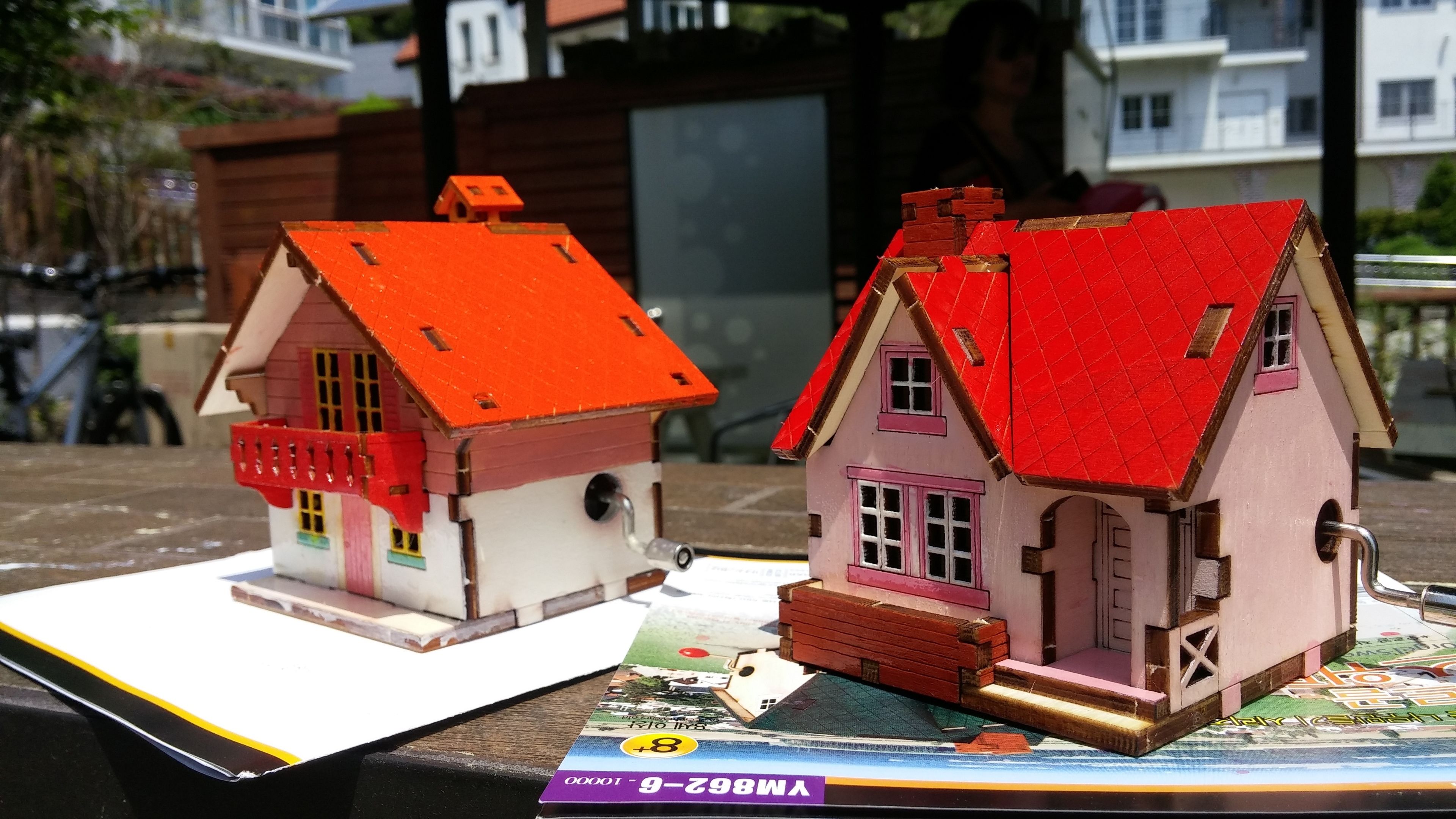 Dos casas modelo con techos rojos sobre una mesa.