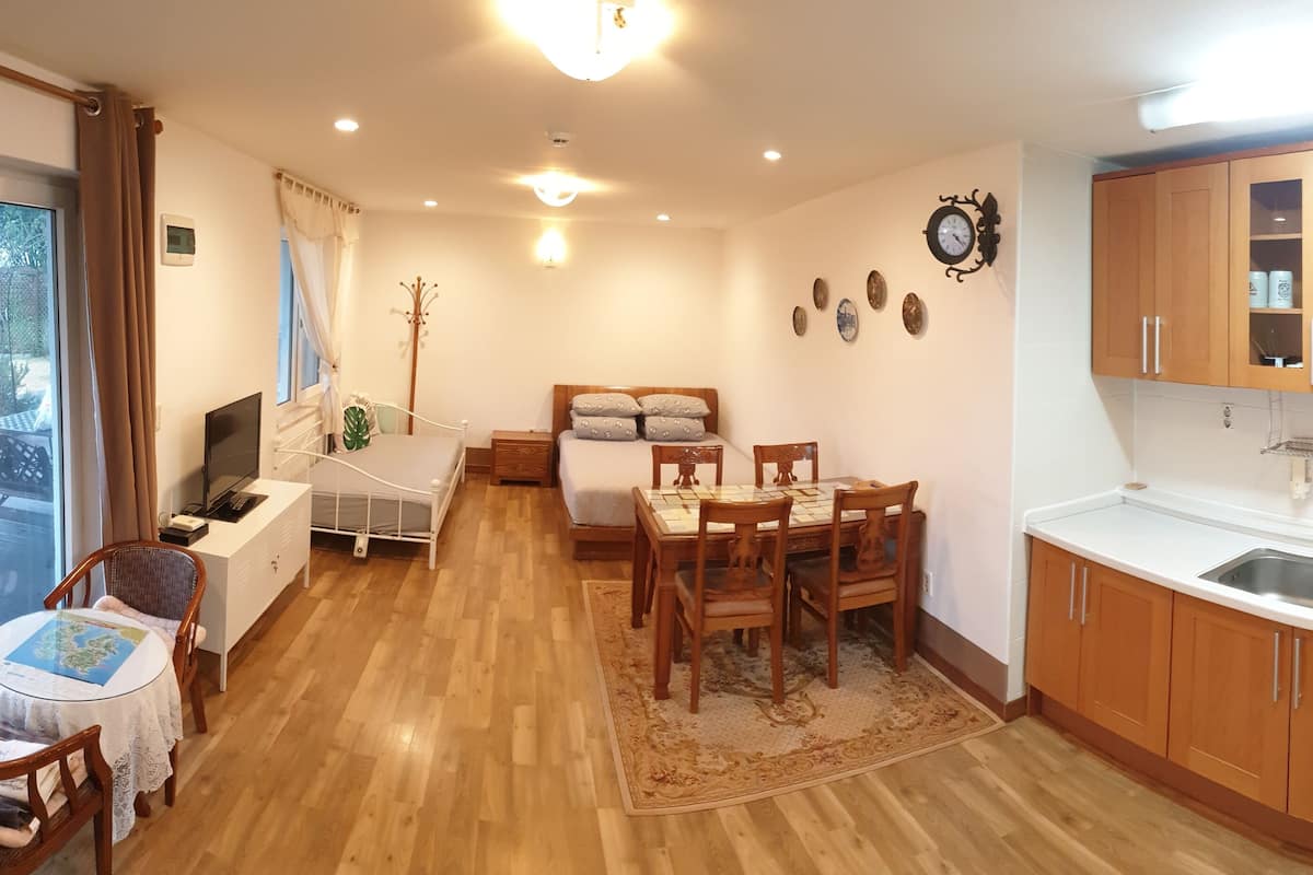 A compact living space with a dining area, a kitchenette, and a bedroom.