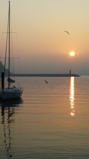 A sailboat anchored near a lighthouse at sunset. - Namhae German Village Neuhaus in Korea (Namhae)