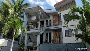 A multi-story building with a balcony, surrounded by palm trees. - Centrium Condominium Hotel (Angeles City)