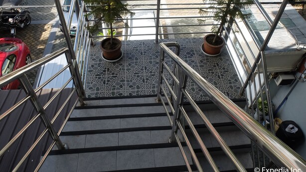 A staircase with metal railings, potted plants, and a tiled floor. - Centrium Condominium Hotel (Angeles City)
