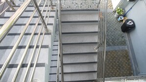A staircase with metal railings, a tiled floor, and potted plants. - Centrium Condominium Hotel (Angeles City)