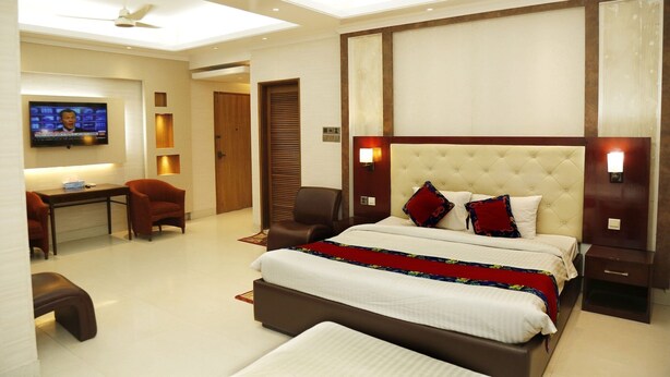 A modern hotel room with a large bed, a desk, and a television. - Sea Shell Residence (Dhaka)