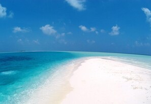 Una playa con agua turquesa cristalina y arena blanca.