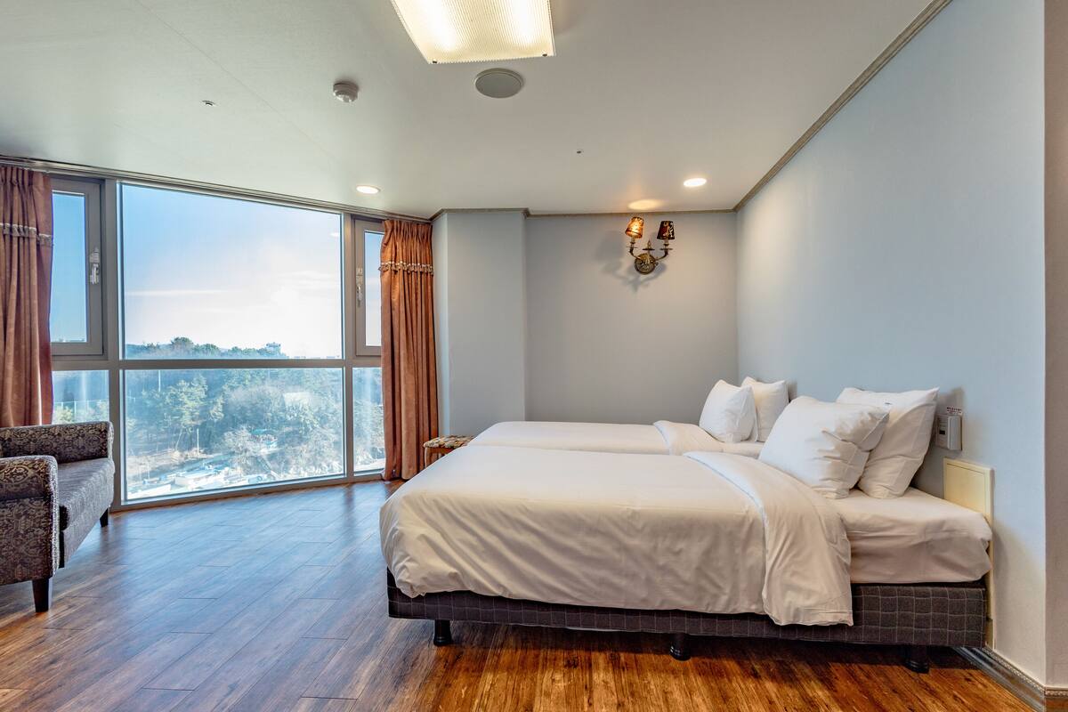 Una habitación de hotel moderna con una cama grande, un sofá y vistas a la ciudad.