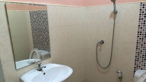 A bathroom with a white sink, a mirror, a shower, and a toilet. - ABC Bungalow (Ko Pha-ngan)