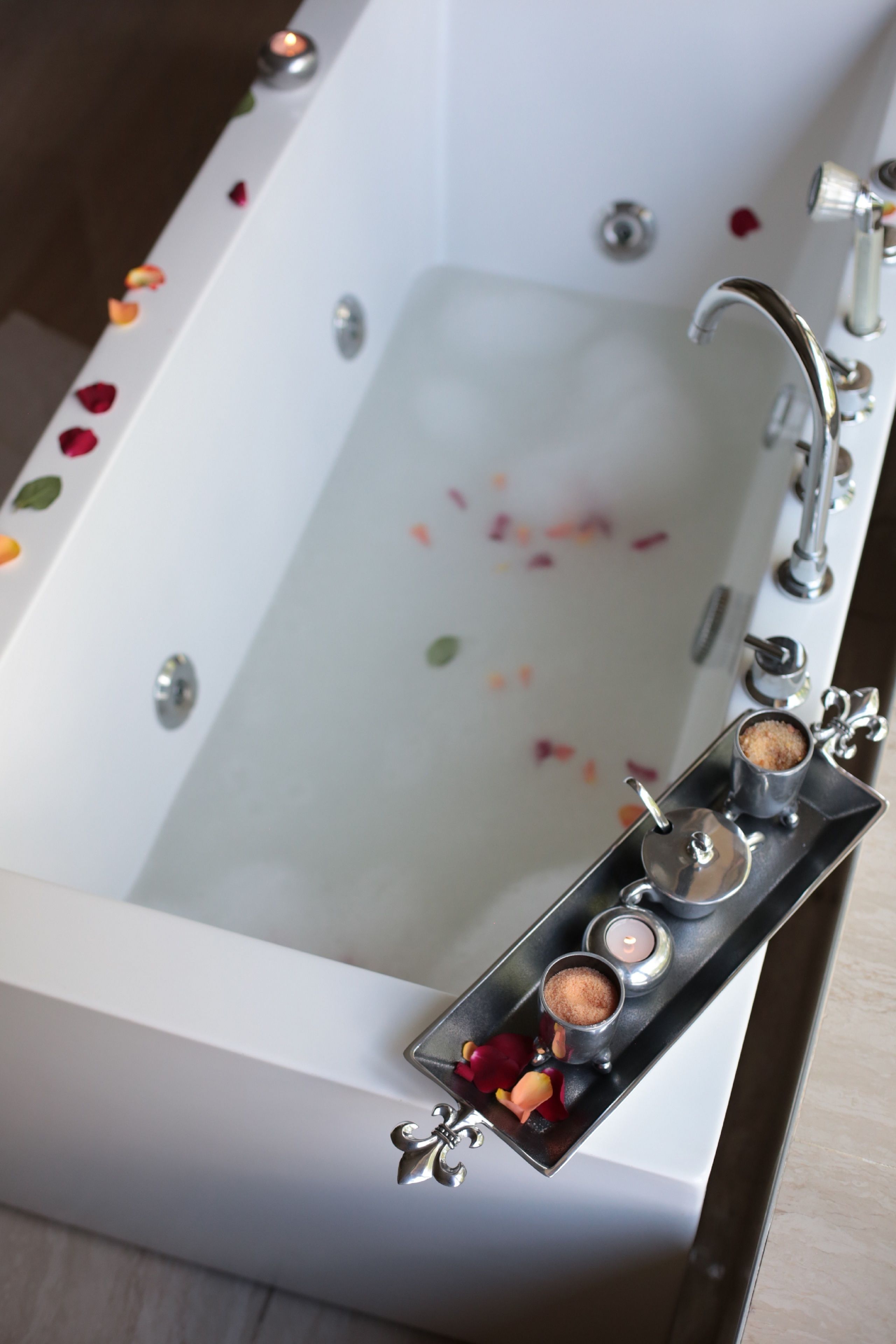 Une baignoire remplie de pétales de roses et décorée de bougies.