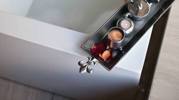 Une baignoire remplie de pétales de roses et décorée de bougies.
