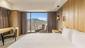 A hotel room with a bed, a desk, a chair, a nightstand, and a view of the outdoors. - La Maison Hotel (Taipei)