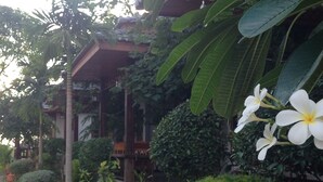 A lush garden with a variety of plants and a prominent white flower. - Khum Laanta Resort (Ko Lanta)