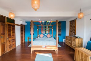 A spacious bedroom with a large bed, wooden wardrobe, and a blue accent wall. - Ock Pop Tok Mekong Villa (Luang Prabang)
