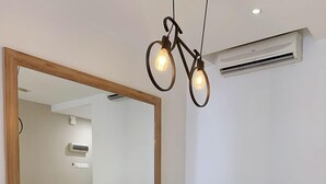 A dining area with a white table and wooden chairs, a large mirror, and pendant lights. - D'Embassy Serviced Residence Suites (Kuantan)