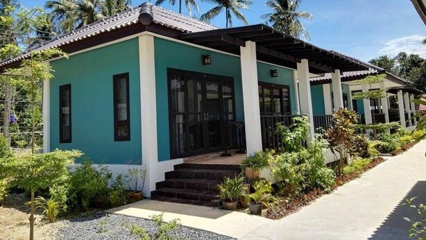 A two-story building with a green facade and a tiled roof, featuring a covered porch and a staircase leading to the entrance. - Lanta Memory Resort (Ko Lanta)