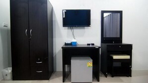 A room with a wardrobe, a desk with a computer monitor, and a small refrigerator. - Lanta Memory Resort (Ko Lanta)