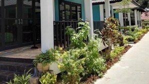 A building with a green facade, white columns, and a covered walkway with potted plants. - Lanta Memory Resort (Ko Lanta)
