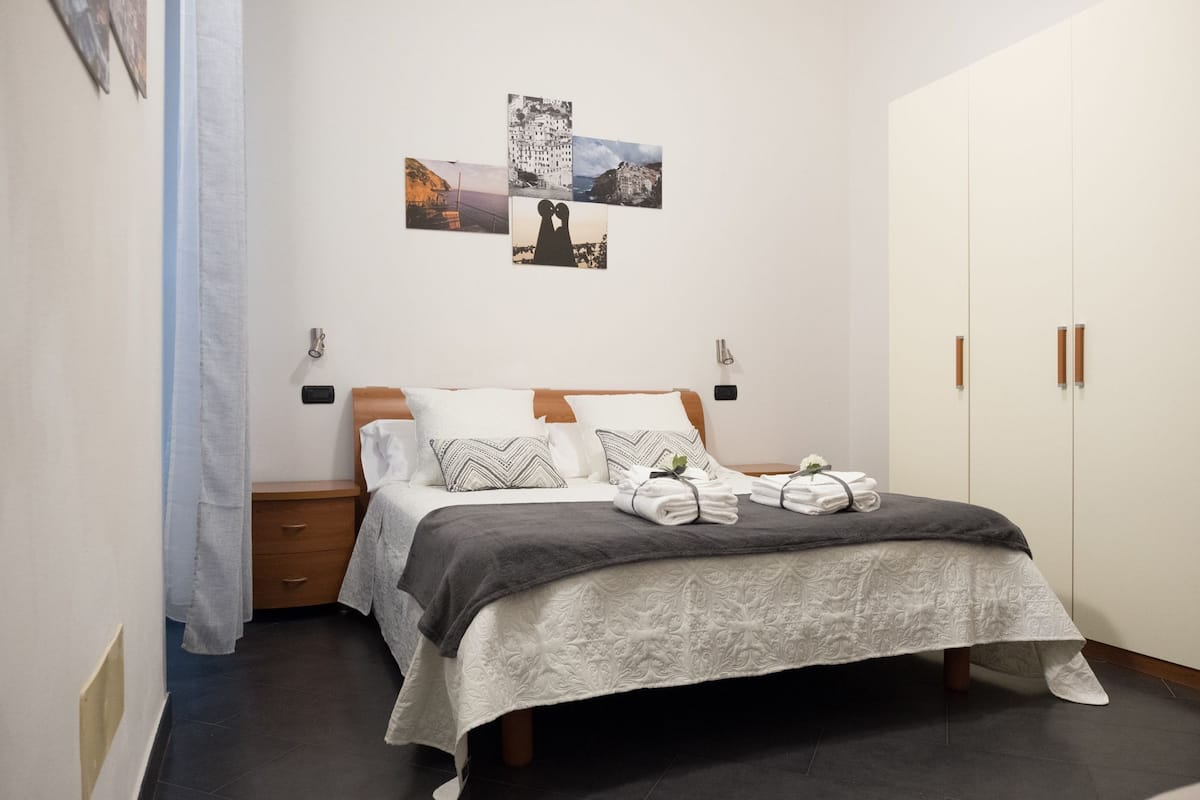 Une chambre à coucher comprenant un lit, des tables de chevet, une armoire et des œuvres d’art murales.