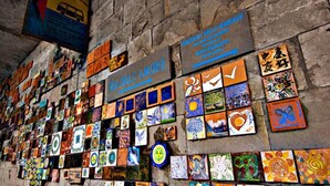 Una pared decorada con coloridas obras de arte y un letrero que dice "VIA DELLA AMORE".