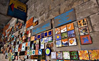 Una pared decorada con coloridas obras de arte y un letrero que dice "VIA DELLA AMORE".