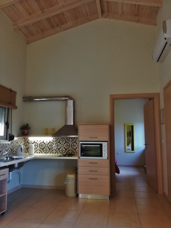 Una cucina con forno integrato, cappa aspirante in acciaio inossidabile e paraschizzi rivestito in piastrelle.