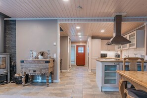 A modern kitchen with a central island, a built-in oven, and a large stove. - Saimaa Life & Light (Imatra)
