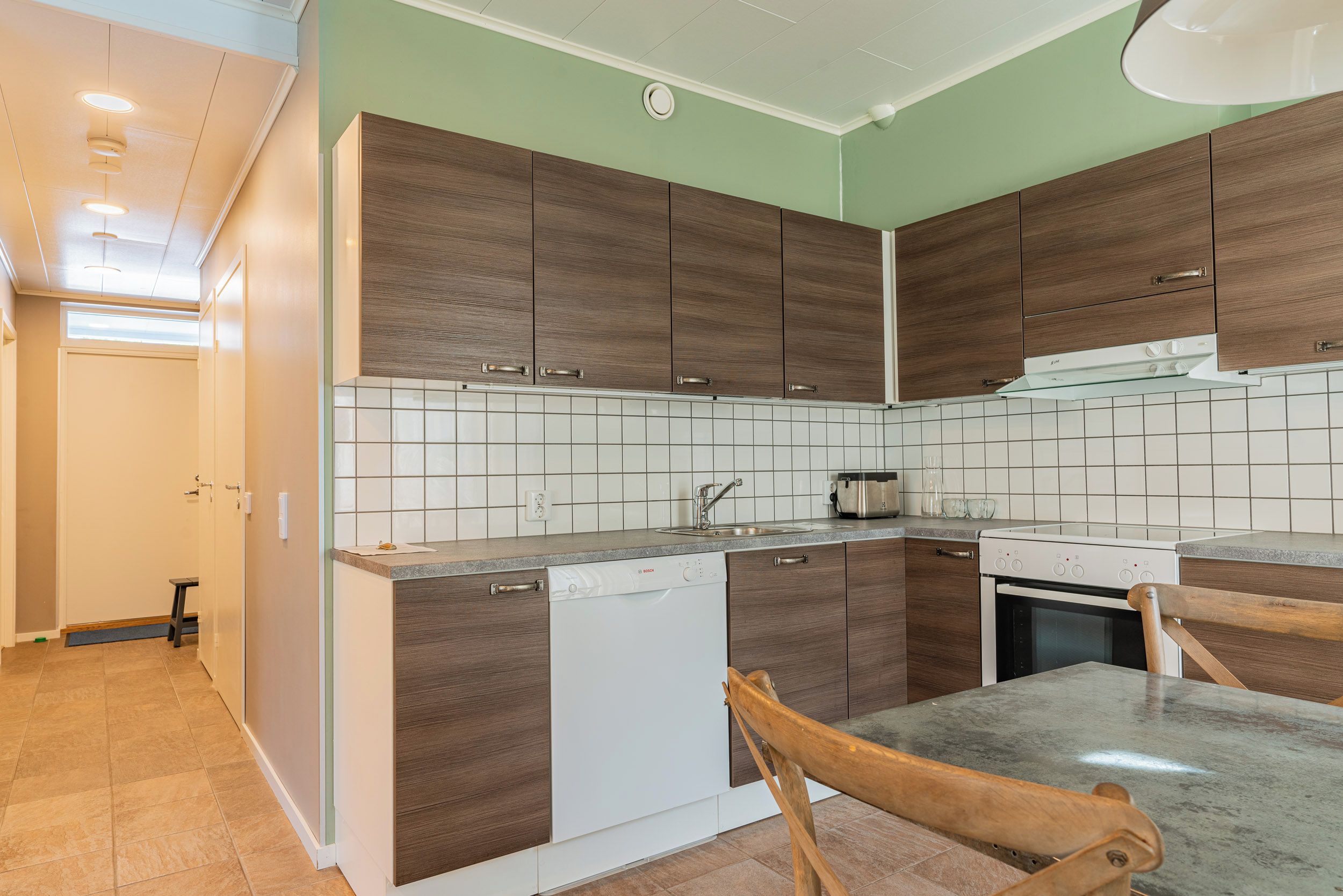 Una cocina moderna con armarios de madera, lavavajillas, estufa y microondas.