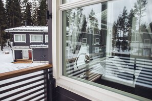 A window with a view of a house and trees.