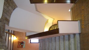 Una scala con corrimano in legno e un lampadario a parete.