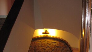 Una scala con un muro in pietra e una ringhiera in legno.
