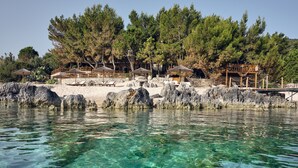 A coastal resort with clear waters, wooden structures, and pine trees. - Nobelos Seaside Lodge (Zakynthos)