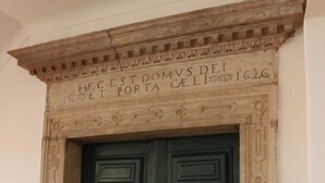 A double door with a stone frame and a plaque above it. - Be Coimbra Hostels (Coimbra)