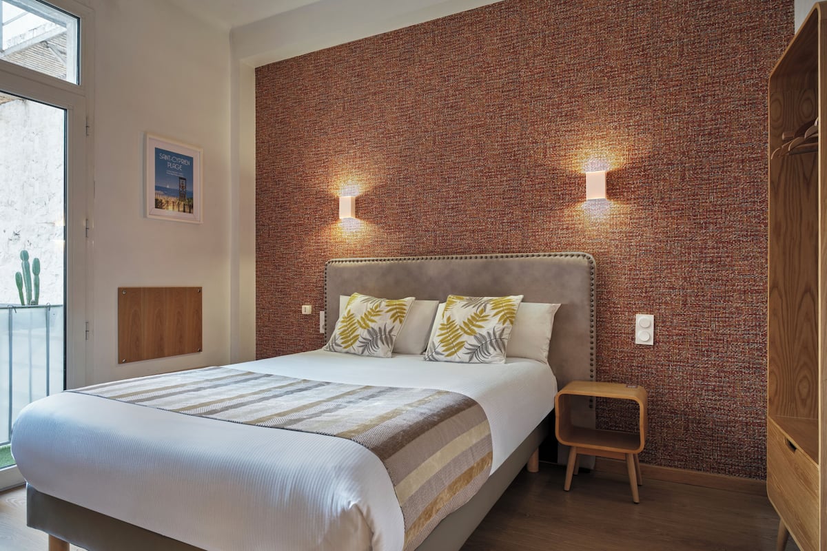 Un dormitorio moderno con una cama grande, un cabecero de madera y una pared con diseño de ladrillo.