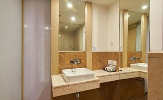 A modern bathroom with two sinks, large mirrors, and a shower area.