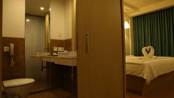 Un baño de hotel con inodoro, lavamanos y espejo.