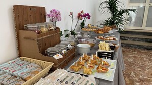 A buffet setup with various food items, including pastries, sandwiches, and condiments. - Hotel Conte (Ischia)