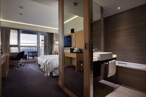 A modern hotel room with a bed, desk, chair, and a large window offering a city view. - K Hotel Taipei SongJiang (Taipei)