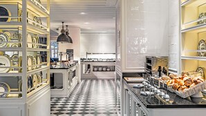 Una cocina moderna con piso a cuadros, armarios blancos y una variedad de vajilla exhibida en estanterías.