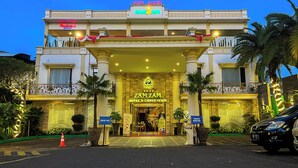 A hotel with a prominent entrance, a sign for 'ZAMZAM HOTEL & CONVENTION', and a 'PARKING MOTOR' sign. - Zamzam Hotel and Convention Batu Powered by Archipelago (Batu)