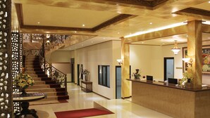 A hotel lobby with a marble reception desk, a staircase with ornate railings, and a red carpet. - Zamzam Hotel and Convention Batu Powered by Archipelago (Batu)