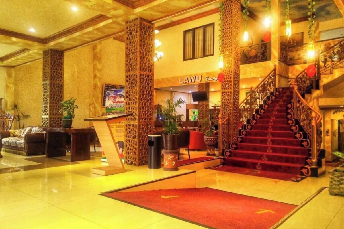 A lobby with a staircase, a reception desk, and a sign that reads 'LAWU'.