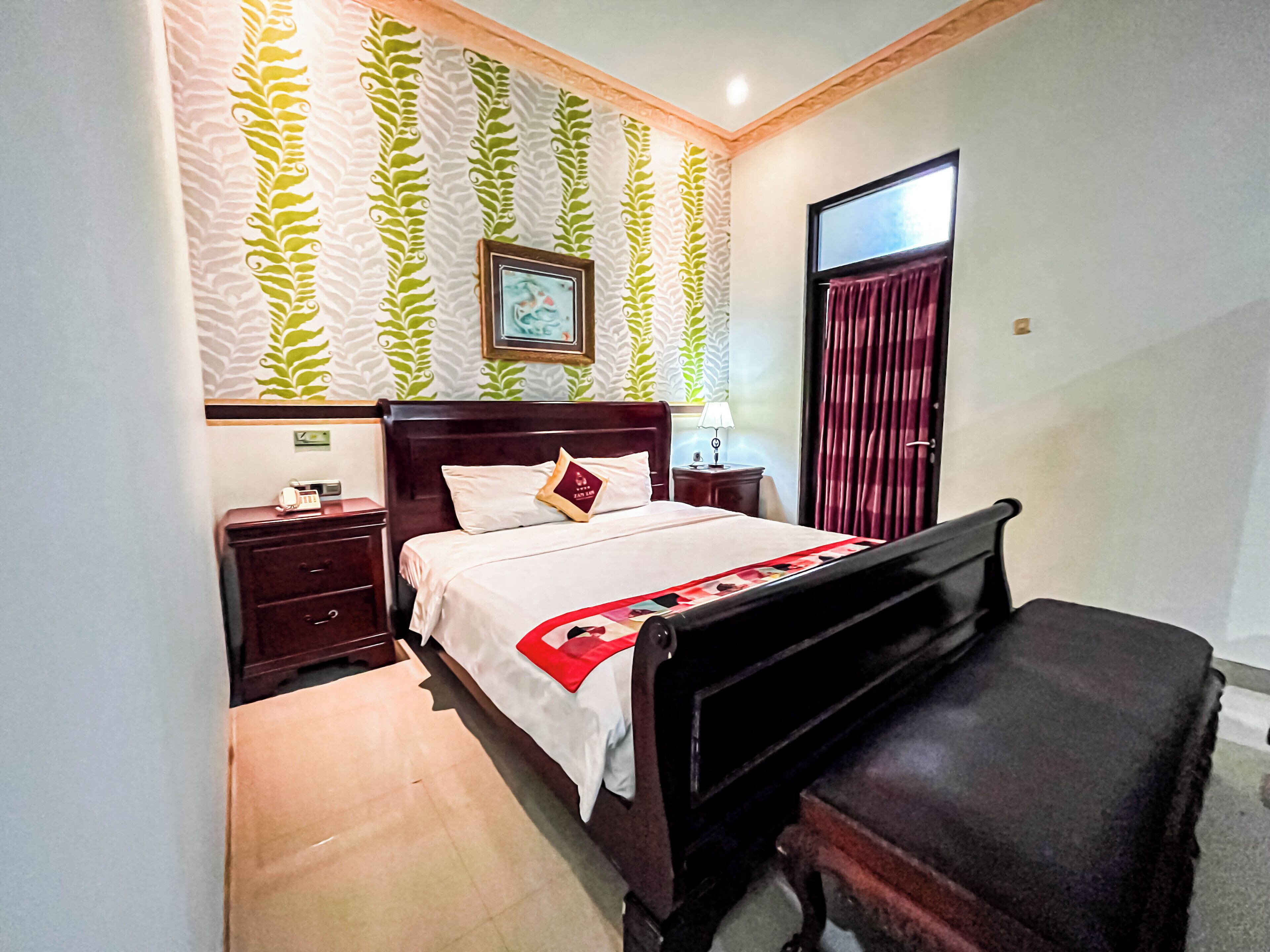 A bedroom with a bed, a nightstand, a dresser, and a desk.