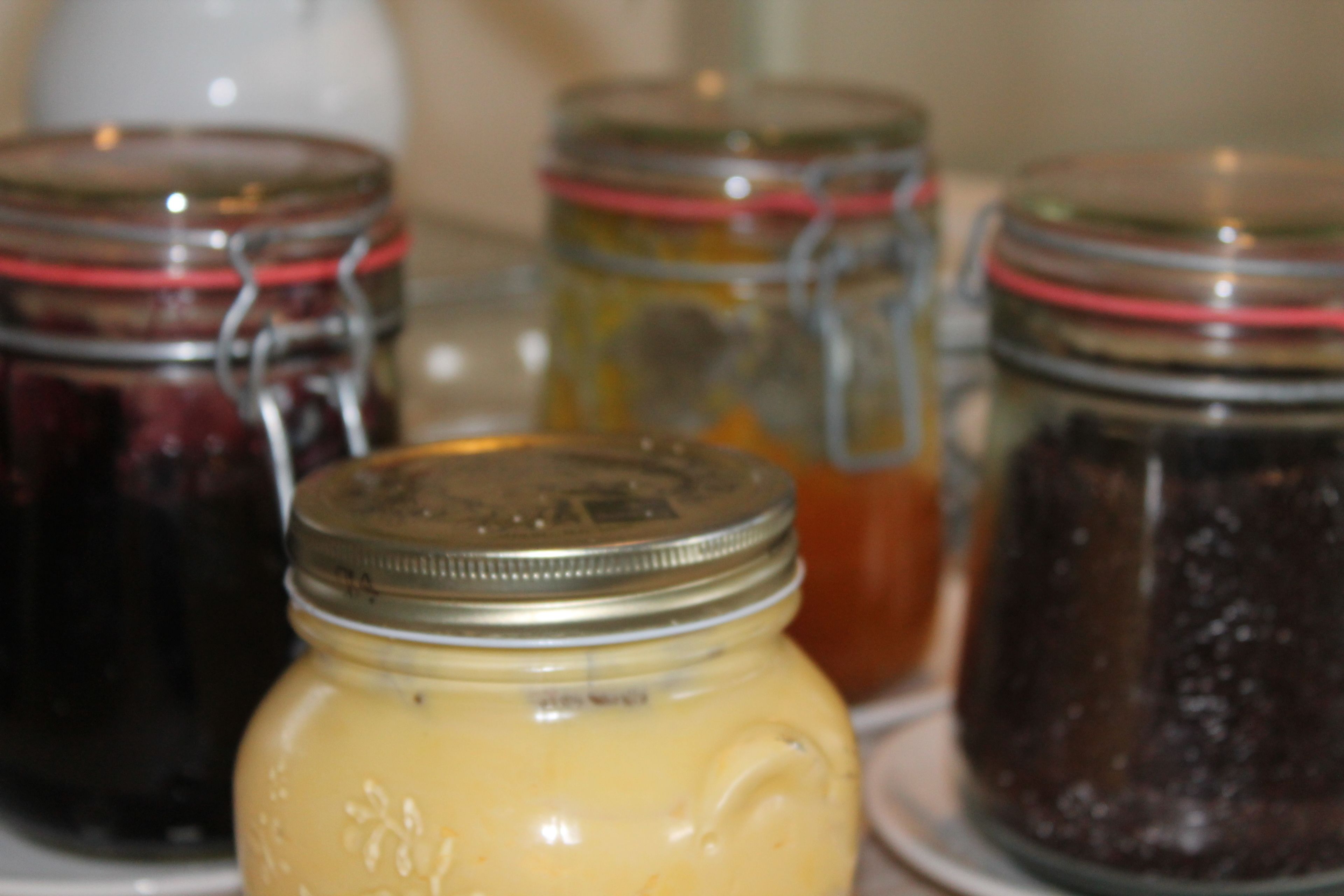 A table with several glass jars containing different preserved foods.
