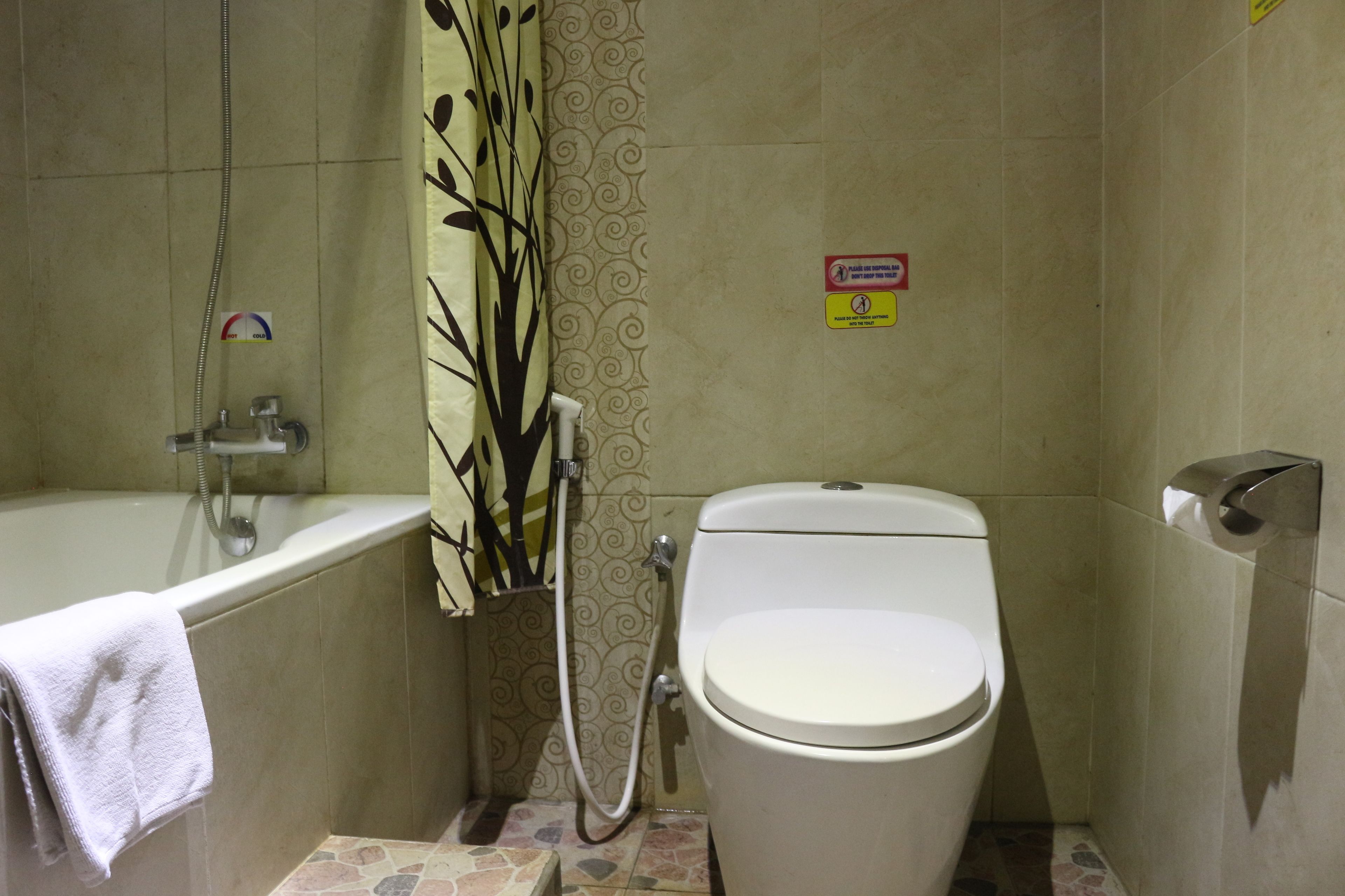 A bathroom with a bathtub, toilet, and shower.