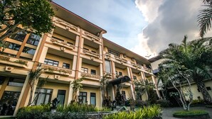 A multi-story hotel with balconies, a courtyard with plants, and a clear sky. - Zamzam Hotel and Convention Batu Powered by Archipelago (Batu)