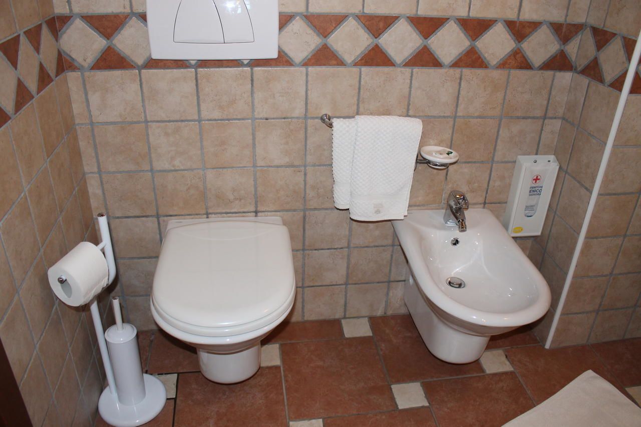 A bathroom with a toilet, bidet, and a towel rack.
