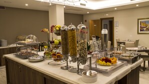 Montaje de bufé con diversos alimentos y una exposición de frutas.