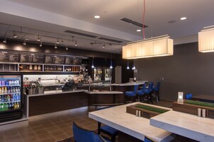 Un área de bar moderna con un tablero de menú, asientos y una barra.