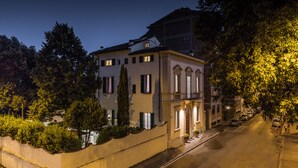 A two-story building with a balcony, a courtyard, and a street view at night. - Hotel Astro Mediceo (Florence)